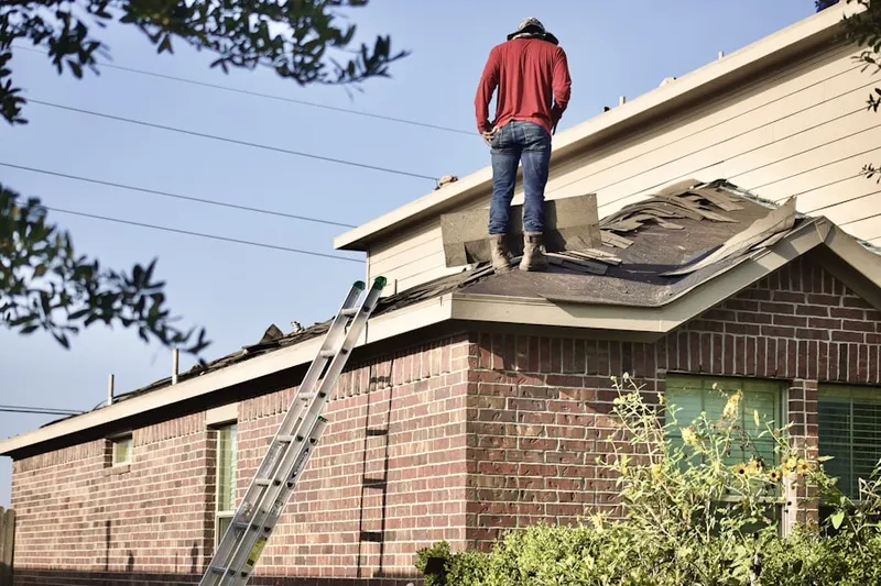 Professional roofer working on a residential roof in Sagamore Forest